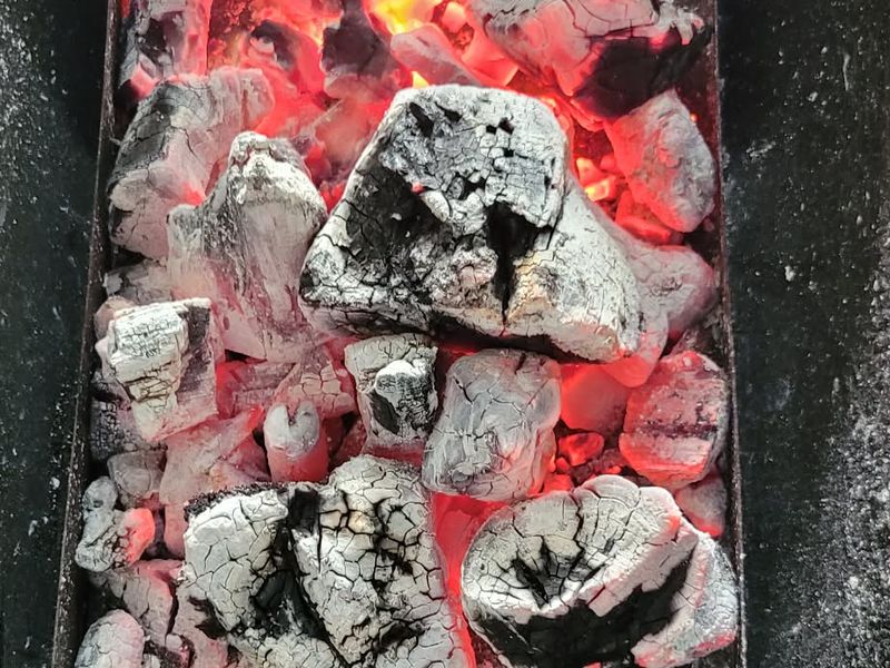 Coffee wood charcoal burning down to embers