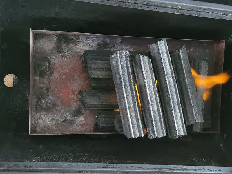Hexagonal sawdust briquettes laid in a firebox