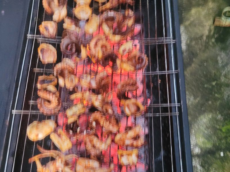 Seafood grilling over charcoal embers