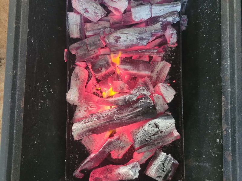 Mangrove charcoal logs burning in a firebox
